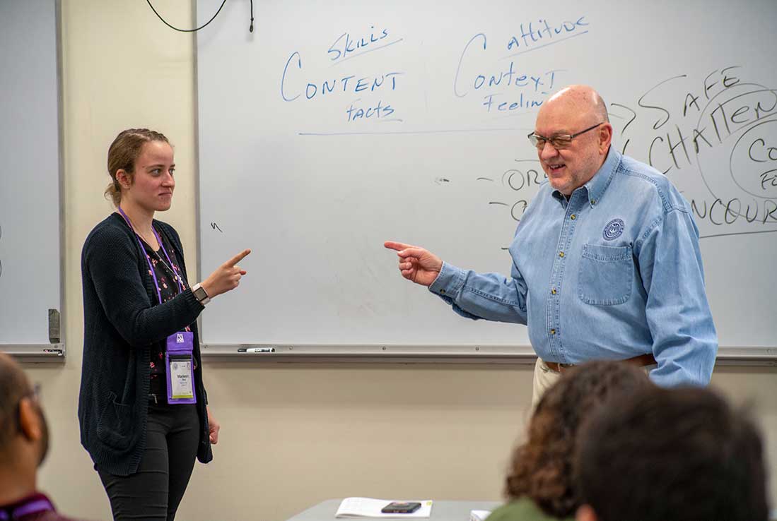 Tim Lautzenheiser demonstrating music education techniques with a music educator.